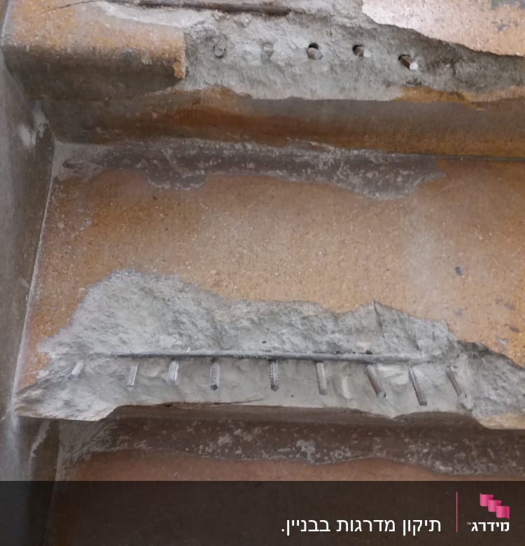 ברגים חשופים בקיר בטון מתקלף במהלך שיפוץ